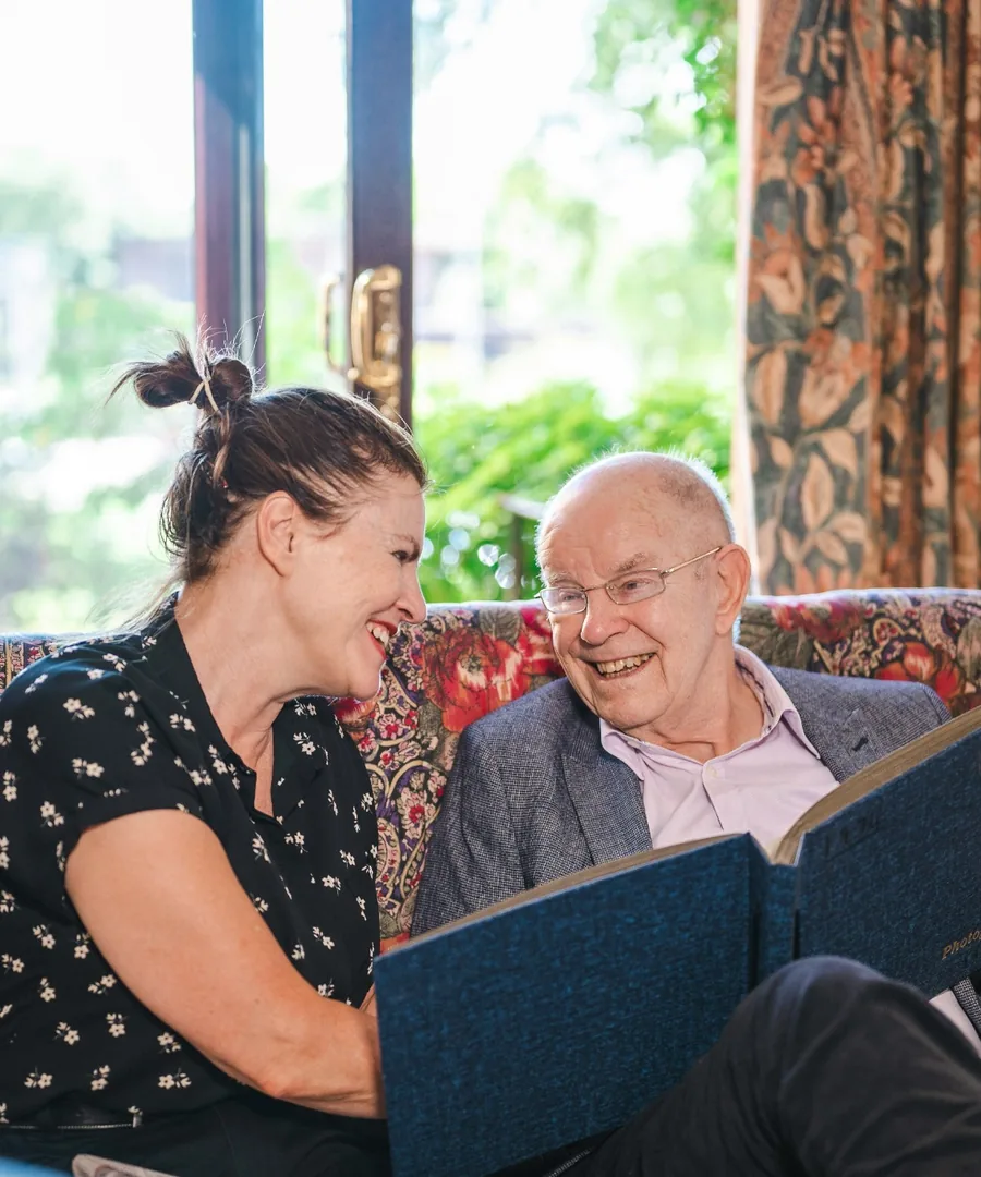 A Menwinnion resident sharing a photo album with a member of the care team